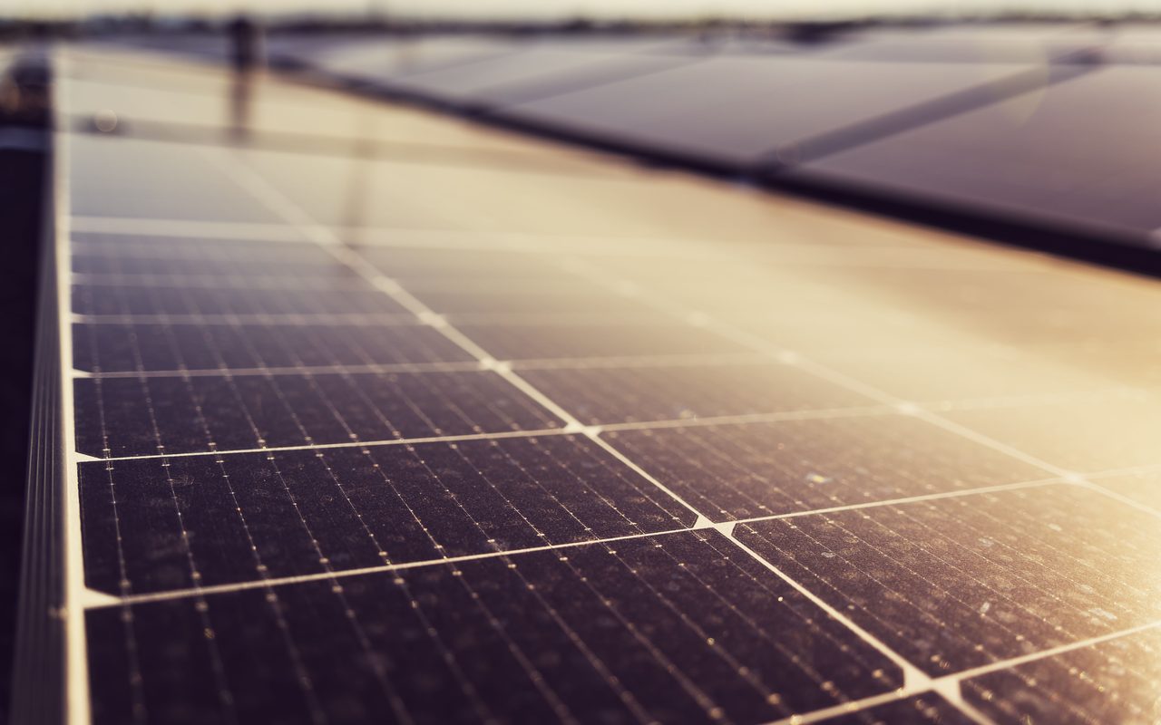 Close-up of a solar panel surface catching golden-hour light