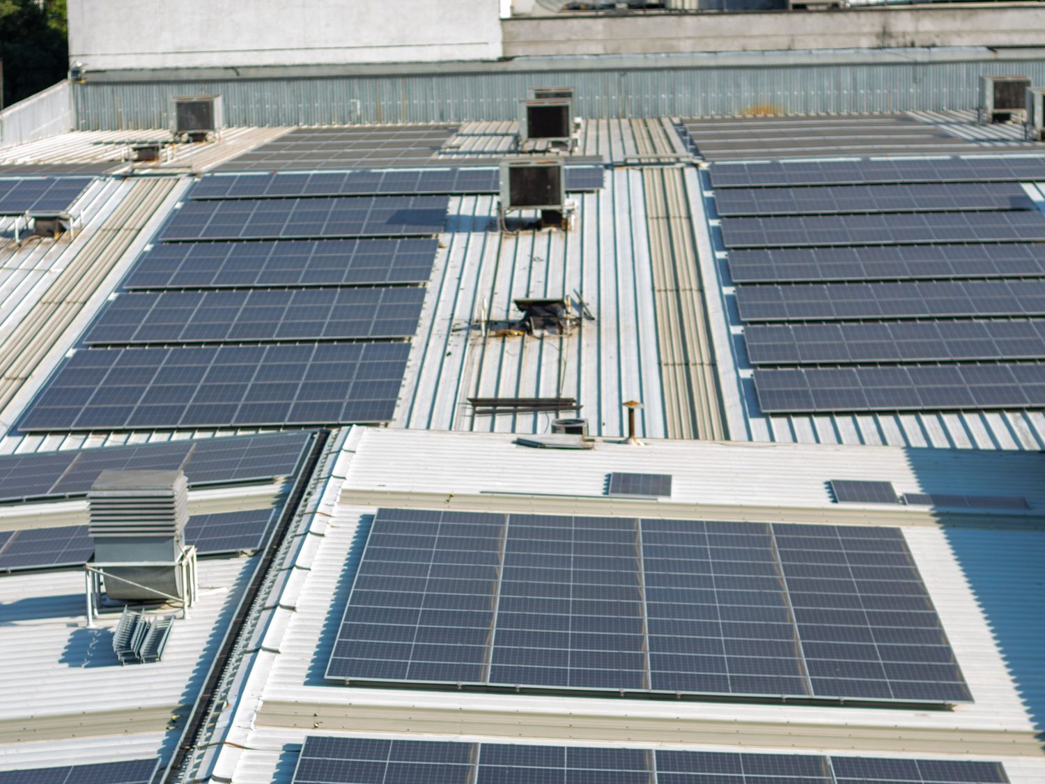 Commercial building roof covered with solar panels above a city skyline
