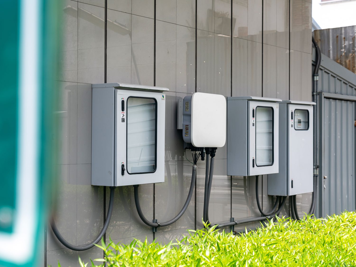 Wall-mounted solar inverters and enclosures wired outside a home