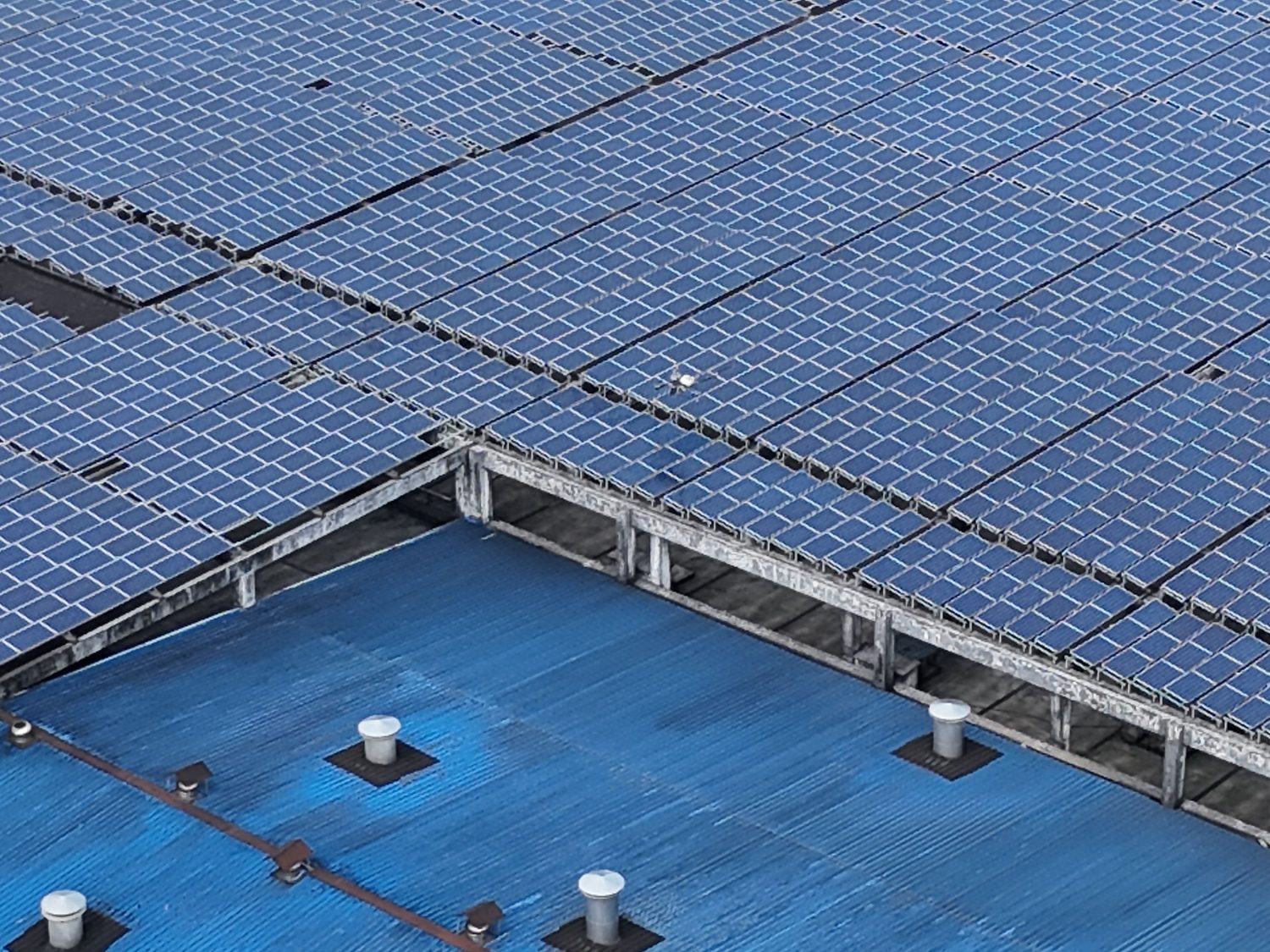 Close aerial detail of a dense rooftop solar panel layout