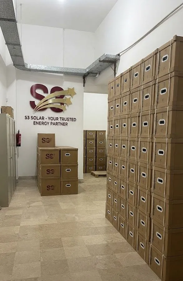 S3 Solar warehouse with the S3 logo on the wall and stacked S3-branded inverter boxes